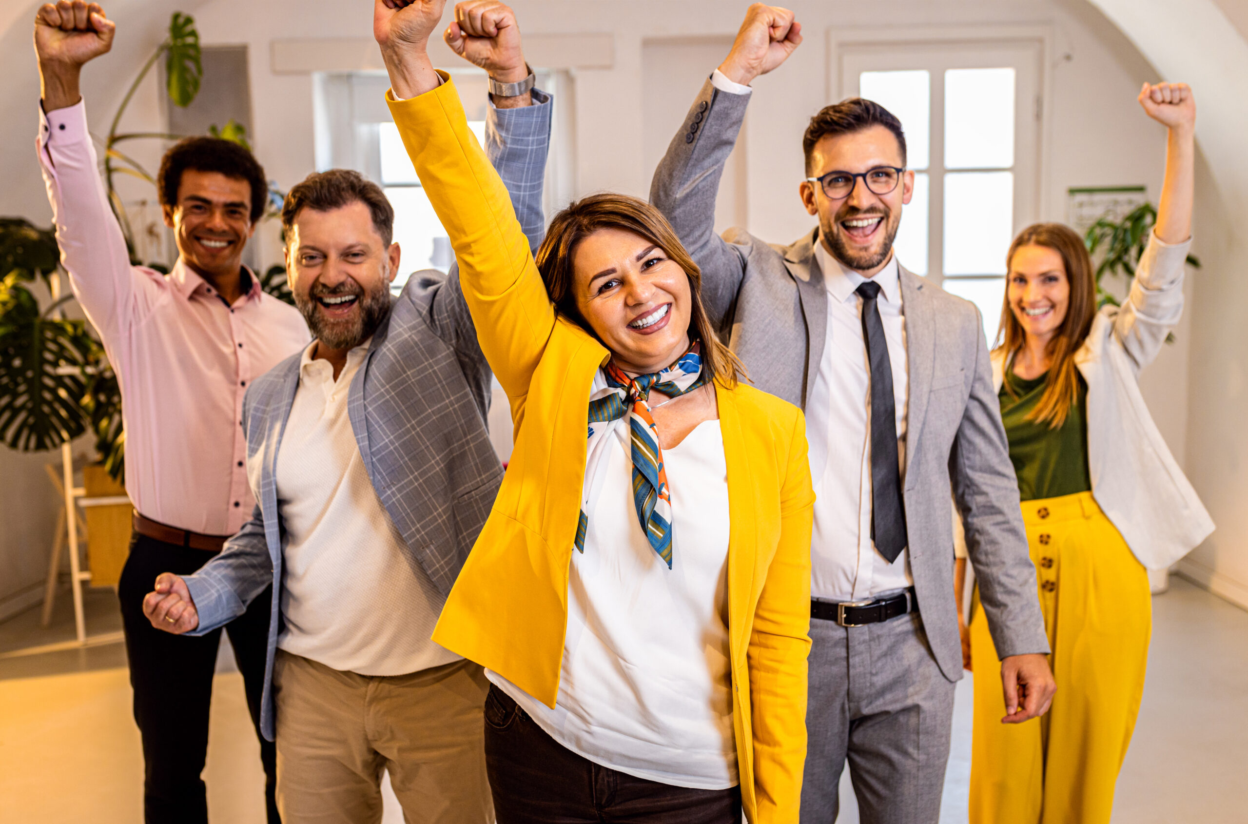 Group of excited business people standing in office. Group of excited business people standing in office.